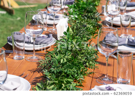 Beautifully decorated wooden table in a summer Beautifully decorated wooden table in a summer 62369059
