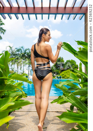 Juicy tropical fruits set at pool edge with 62369232