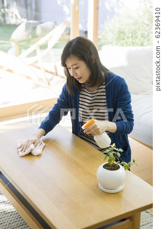 Young woman wiping center table Young woman wiping center table 62369410