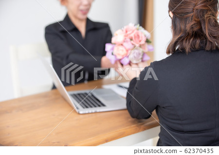 Female staff handing a bouquet Female staff handing a bouquet 62370435