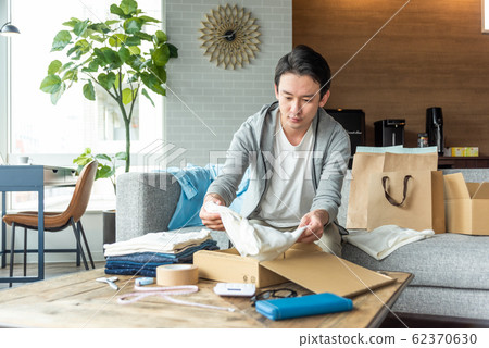年輕人打包箱子放不需要Mercari的衣服 62370630