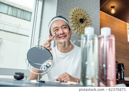 Makeup boy: A man who uses a facial device to pay attention to his skin 62370871