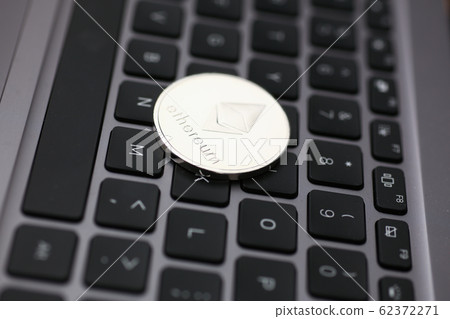 Silver ethereum coin is lying on laptop 62372271