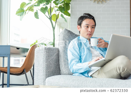 在家研究膝上型計算機的年輕女實業家在客廳 62372330