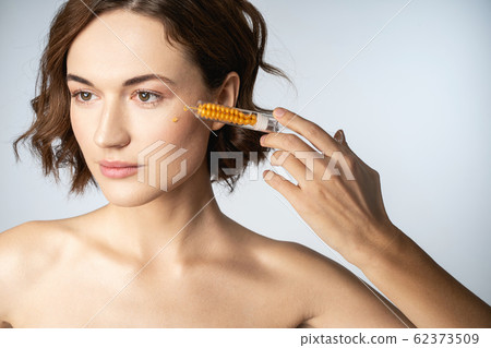 Close up of young woman that using hyaluronic acid Close up of young woman that using hyaluronic acid 62373509