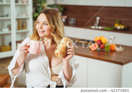 Relaxed young woman going to drink aroma tea Relaxed young woman going to drink aroma tea 62373903