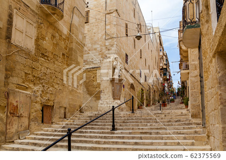 A narrow medieval street with stone stairs in an 62375569