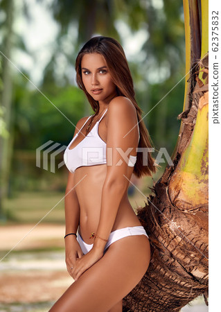 Beautiful girl in white bikini posing at the 62375832