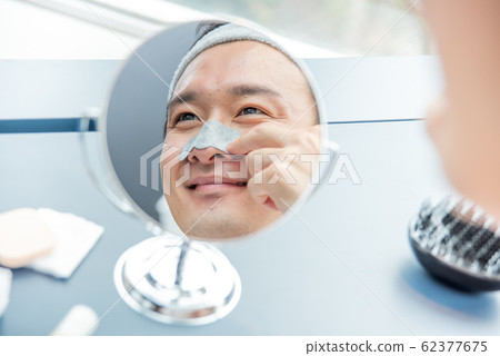 化妝男孩一個年輕的男孩,照顧她的皮膚,收拾鼻子 化妝男孩一個年輕的男孩,照顧她的皮膚,收拾鼻子 62377675