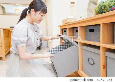 Young woman clearing shelves 62379753