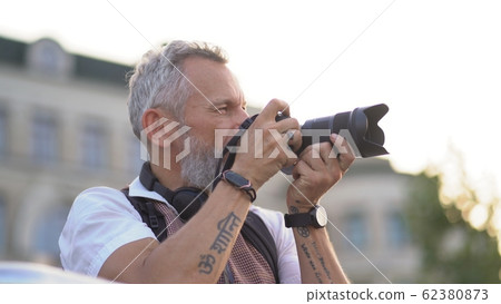 Light-skinned hipster takes a photo of the city 62380873