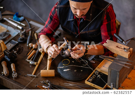 Goldsmith making a ring for a client 62382557