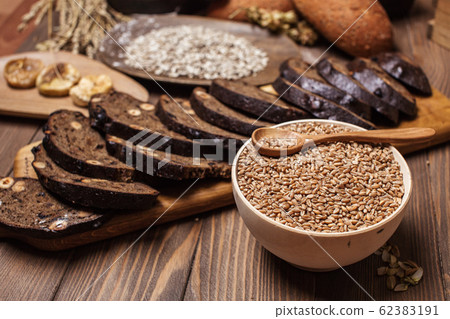 Whole grain multigrain bread, whole and sliced, contains seeds isolated on black 62383191