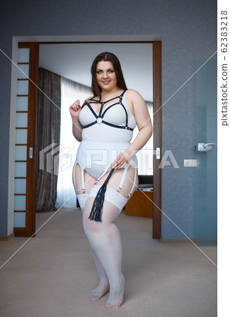 Overweight depraved woman holding leather whip 62383218