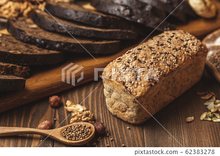 Whole grain multigrain bread, whole and sliced, contains seeds isolated on black 62383278