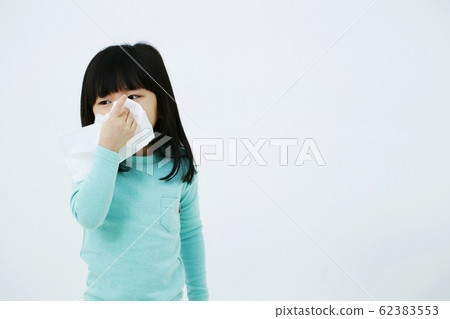 Girl blowing nose with tissue paper Girl blowing nose with tissue paper 62383553