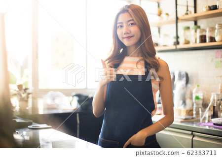 Portrait young Asian woman barista feeling happy 62383711
