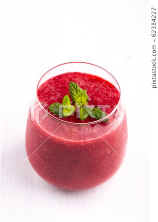 Glass of strawberry and raspberry smoothie 62384227