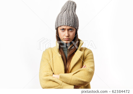 Confused and offended caucasian woman in colorful winter clothes posing indoors 62384472