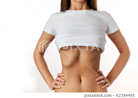 Close up of slim young woman belly isolated on white. Close up of slim young woman belly isolated on white. 62384493