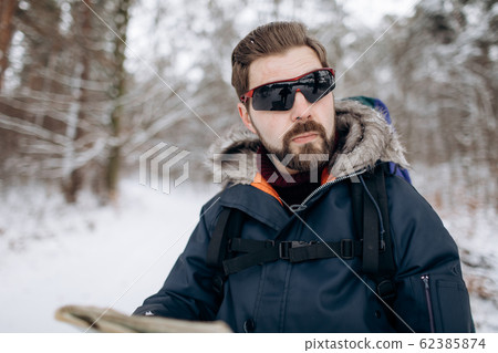 Virile Bearded Tourist in Mirrored Sunglasses in Winter Forest Virile Bearded Tourist in Mirrored Sunglasses in Winter Forest 62385874