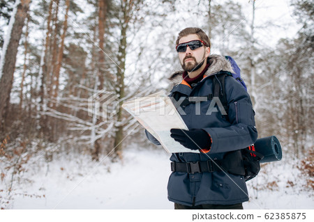 Hiker Checking Map to Orientate in Snow-clad Forest Hiker Checking Map to Orientate in Snow-clad Forest 62385875