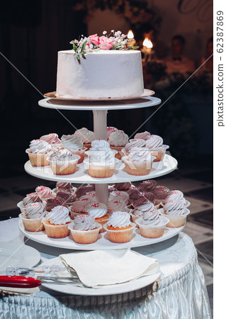 Beautiful wedding cake with flowers on table Beautiful wedding cake with flowers on table 62387869