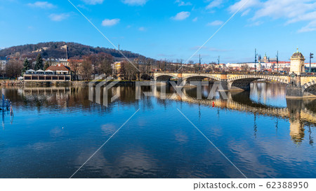 Legion Bridge, Czech: Most legii, reflected in Vltava River with Prague Castle and Petrin Hill on background. Clear sunny winter day in Prague, Czech Republic Legion Bridge, Czech: Most legii, reflected in Vltava River with Prague Castle and Petrin Hill on background. Clear sunny winter day in Prague, Czech Republic 62388950