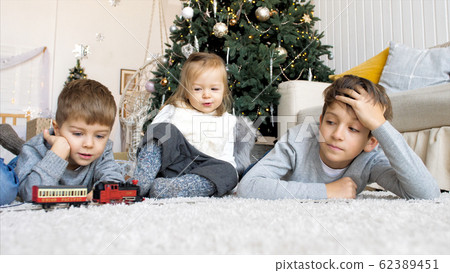 Children playing with railroad at home together in Christmas eve 62389451