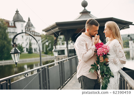 Beautiful couple spend time in a summer garden Beautiful couple spend time in a summer garden 62390459