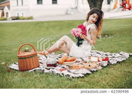 Elegant and stylish girl in a summer garden Elegant and stylish girl in a summer garden 62390496
