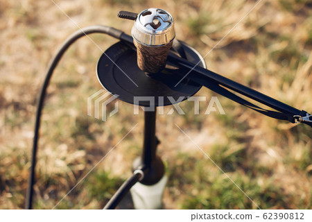 Cropped view of preparing tobacco for shisha on table outside Cropped view of preparing tobacco for shisha on table outside 62390812