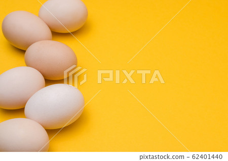 natural ecological eggs on yellow background in a row with copyspace 62401440