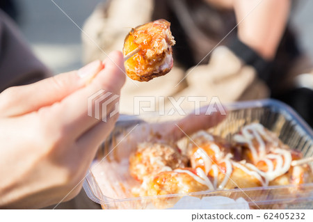 Woman eating takoyaki at fair 62405232