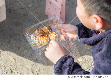 Children eating takoyaki at the fair 62405233
