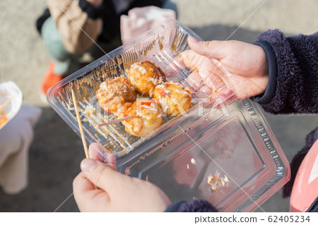 Children eating takoyaki at the fair Children eating takoyaki at the fair 62405234