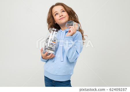 Cute girl with a glass jar and money on a white background. finance 62409287