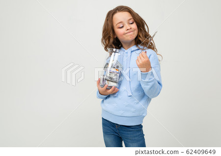 Cute girl with a glass jar and money on a white background. finance 62409649