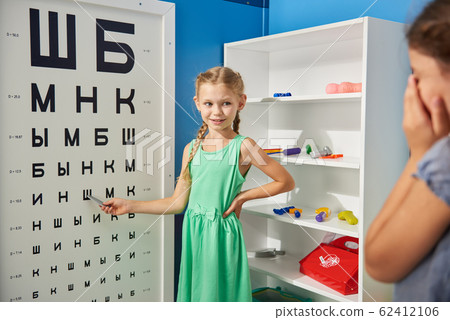 Little girls playing a doctor ophthalmologist. 62412106