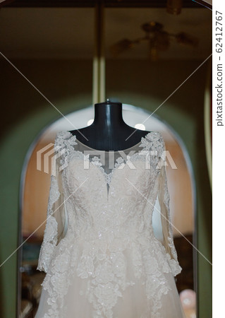 Beautiful wedding dress on a hanger on a happy Beautiful wedding dress on a hanger on a happy 62412767