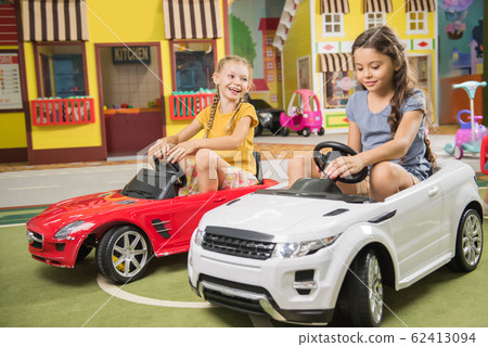 Kids drive car in entertainment center. 62413094