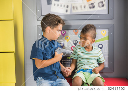 Two little boys playing police at playground. Two little boys playing police at playground. 62413302