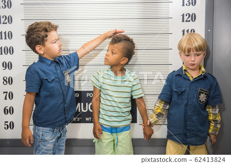 Elementary school boys playing police and prisoner. Elementary school boys playing police and prisoner. 62413824