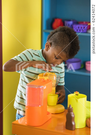 Little boy playing with toy in toy kitchen. 62414072