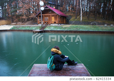 the girl is sitting with her back on a wooden 62415334