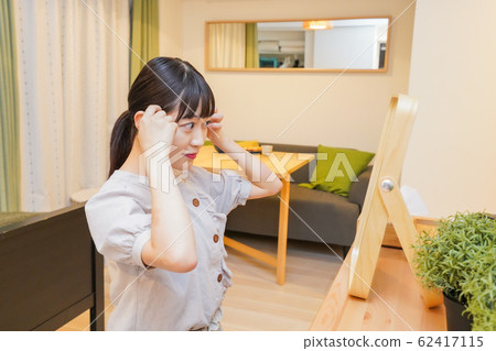 Young woman doing hair set 62417115