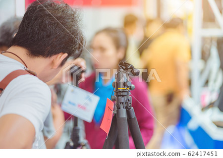 Tripod camera for sale at Trade show on photography equipment. 62417451