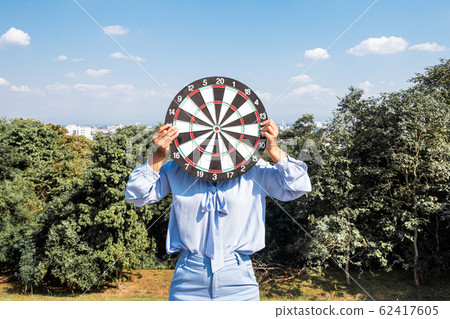Business young woman holding dartboard with blue sky and clouds, Planning new business target and goals 62417605