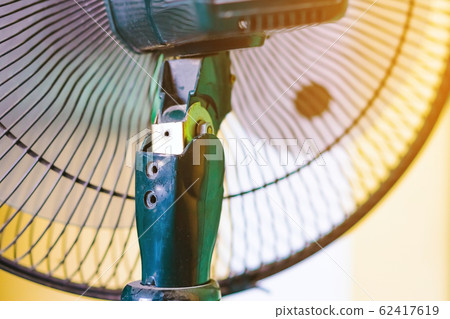 Close up to the old plastic joints of the electronic fan damaged and broken with a blurred background. Selective focus Close up to the old plastic joints of the electronic fan damaged and broken with a blurred background. Selective focus 62417619
