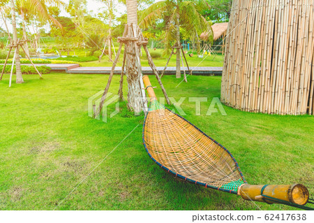 Bamboo wicker hammock hanging on tree for relaxing in the public garden. 62417638